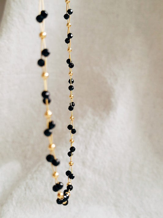 Close-up of a black spinel beaded choker necklace with 22k gold accents, styled for minimalist everyday wear. Handmade in natural gemstone and gold plated sterling silver premium materials, perfect gift for anniversary, birthday or self care.