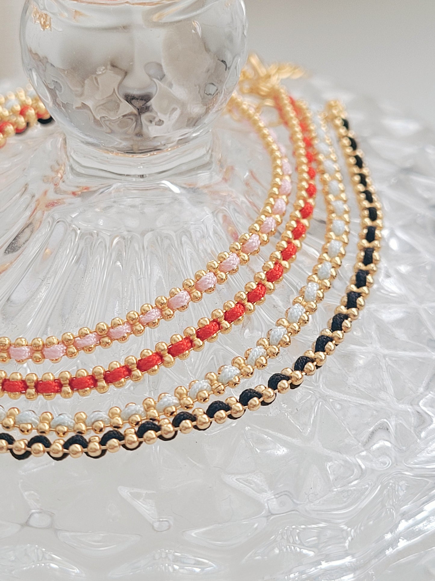 Gold-plated sterling silver string bracelets in Black, Blue, Red and Pink, perfect as friendship bracelets or meaningful graduation gifts for everyday wear.