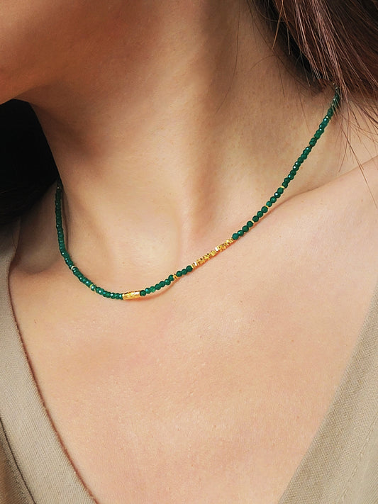 A close-up of a woman's neck wearing a Green Onyx Beaded Necklace with 18k Gold Vermeil beads, showcasing an elegant minimalist design perfect for everyday wear or special occasions.