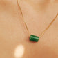 A natural green jade bead necklace with a polished finish, strung on a gold-plated sterling silver chain, offering a minimalist and elegant style.