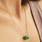 A natural green jade bead necklace with a polished finish, strung on a gold-plated sterling silver chain, offering a minimalist and elegant style.