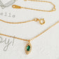 Close-up of a marquise emerald green evil eye pendant necklace on a delicate gold chain, showcasing its dainty and elegant vintage-inspired design.