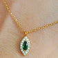 Close-up of a marquise emerald green evil eye pendant necklace on a delicate gold chain, showcasing its dainty and elegant vintage-inspired design.