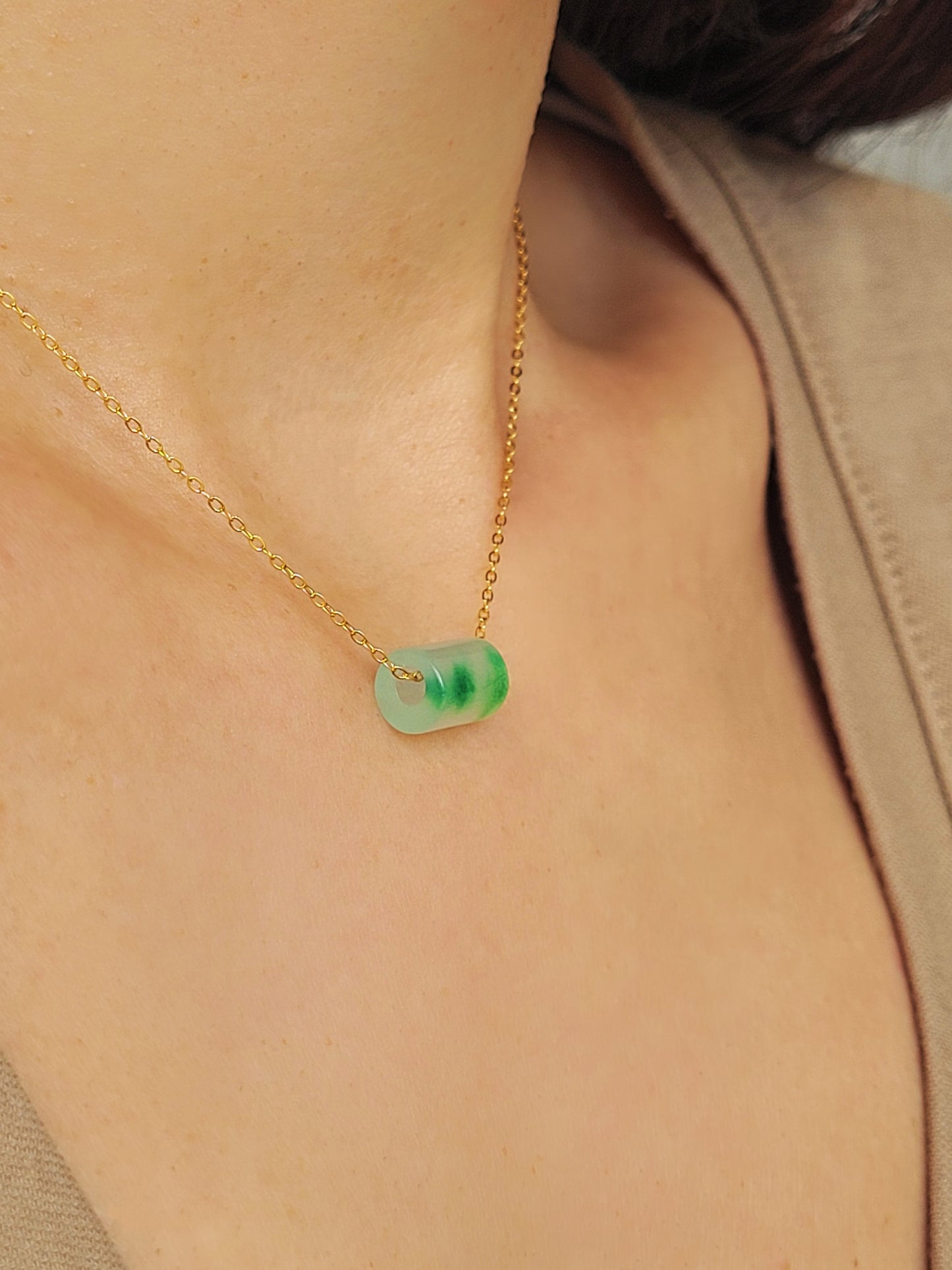 A close-up of a pair of natural jade charm necklace, featuring an icy green jade or icy blue jade pendant on a gold-plated sterling silver chain, showcasing a delicate and elegant look.