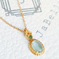 Close-up of pale blue topaz oval pendant necklace with vintage gold detailing. Perfect birthday gift for her.