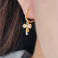 Close-up view of a woman's ear wearing ribbon bow earring with a dangling design, perfect for gifting to girlfriends, daughters, or loved ones.