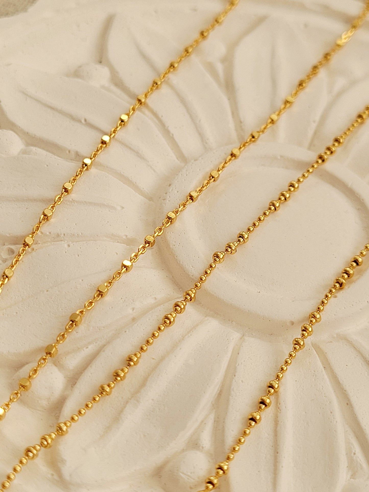 Stylish gold plated sterling silver chain necklace displayed on a white surface