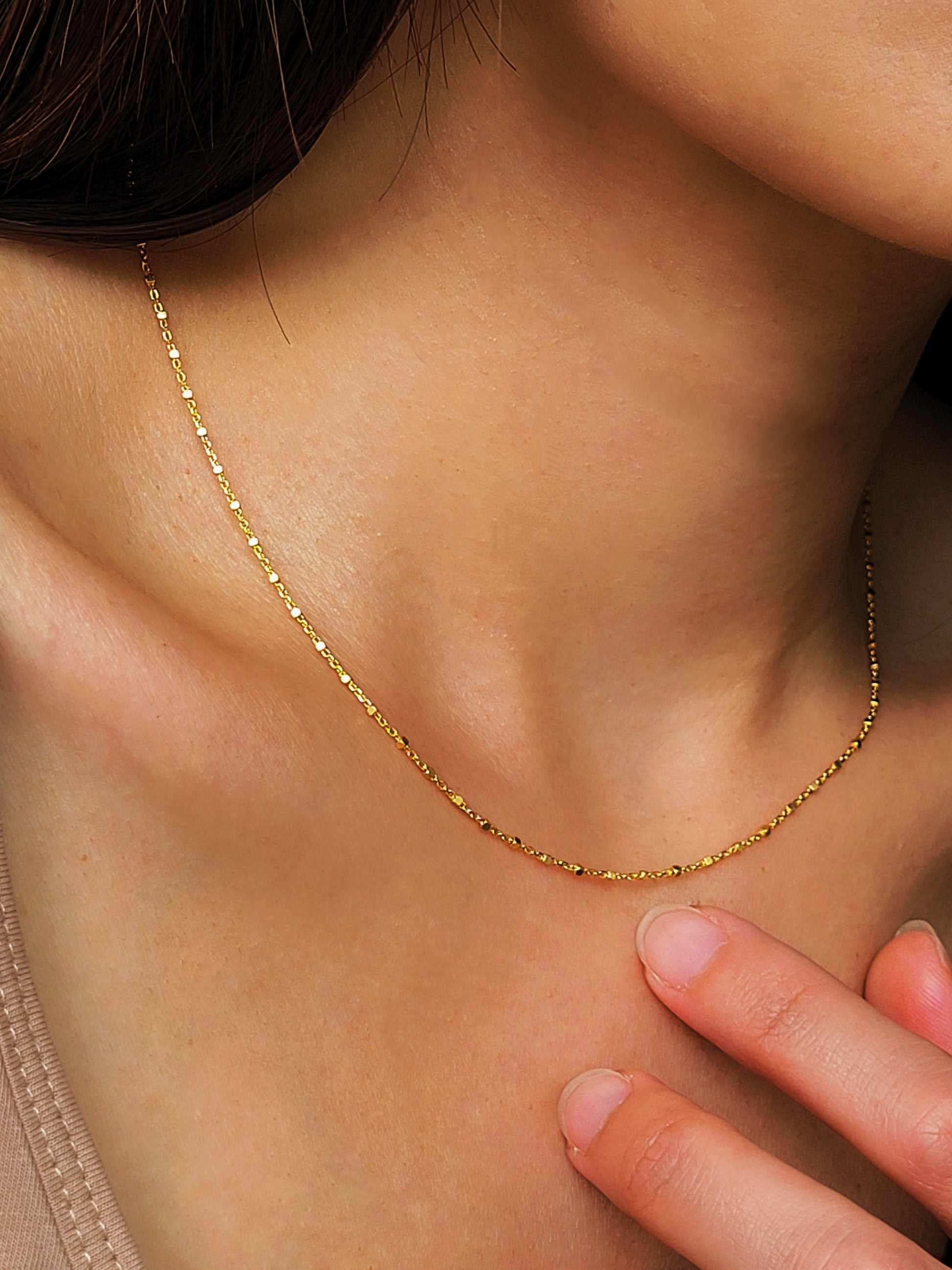 Model wearing a gold chain beaded necklace crafted in 18k gold plated sterling silver, showcasing its minimalist and dainty details