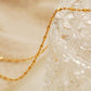 Close up of a gold chain necklace on a glassware