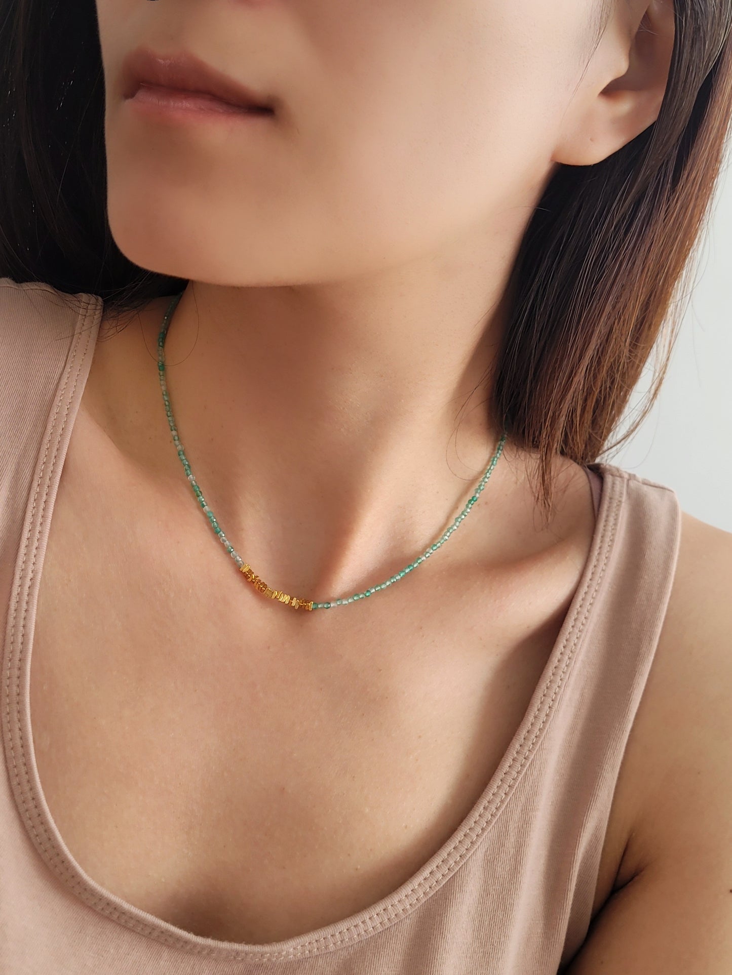 A woman wearing green onyx beaded gemstone choker necklace with gold vermeil accents, showing casing minimalist and elegant style. Perfect gift for her.