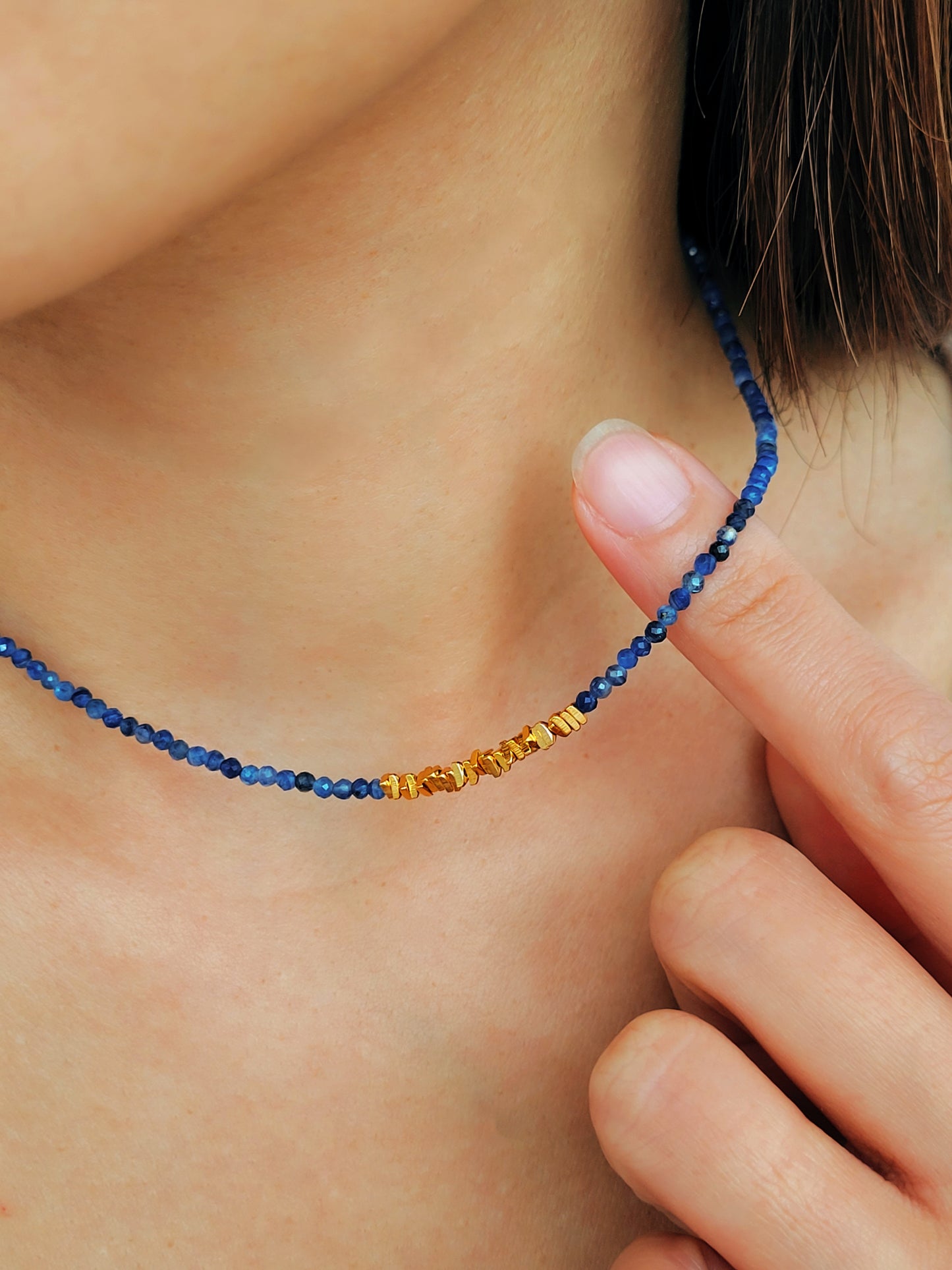 A woman wearing kyanite beaded gemstone choker necklace with gold vermeil accents, showing casing minimalist and elegant style. Perfect gift for her.