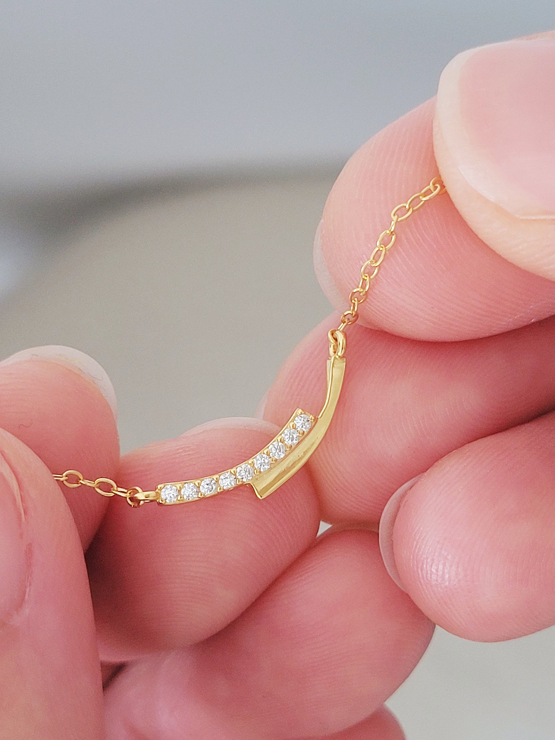 Close up of a gold bar necklace crafted in gold plated sterling silver with zirconia accents.