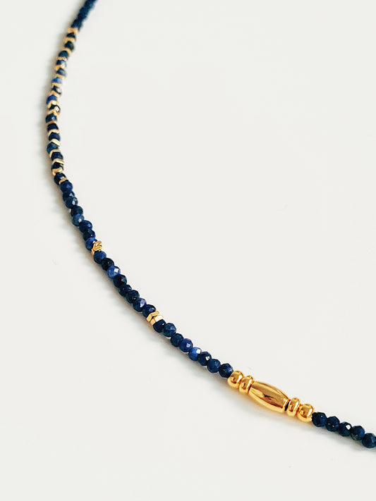 A delicate Lapis Lazuli beaded necklace featuring deep blue 2mm faceted gemstones and accented with 18k gold vermeil beads, styled as a minimalist choker necklace, perfect for gifting on birthdays, anniversaries, or special occasions.