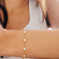 A woman elegantly wearing a gold opal bracelet and earrings, emphasizing her refined taste in jewelry and fashion.