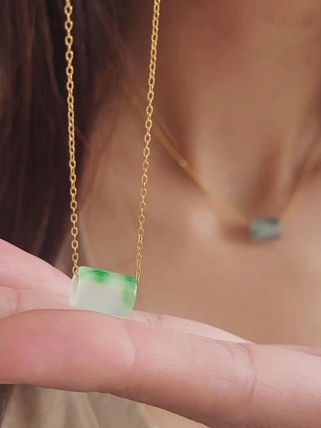 A close-up of a pair of natural jade charm necklace, featuring an icy green jade or icy blue jade pendant on a gold-plated sterling silver chain, showcasing a delicate and elegant look.