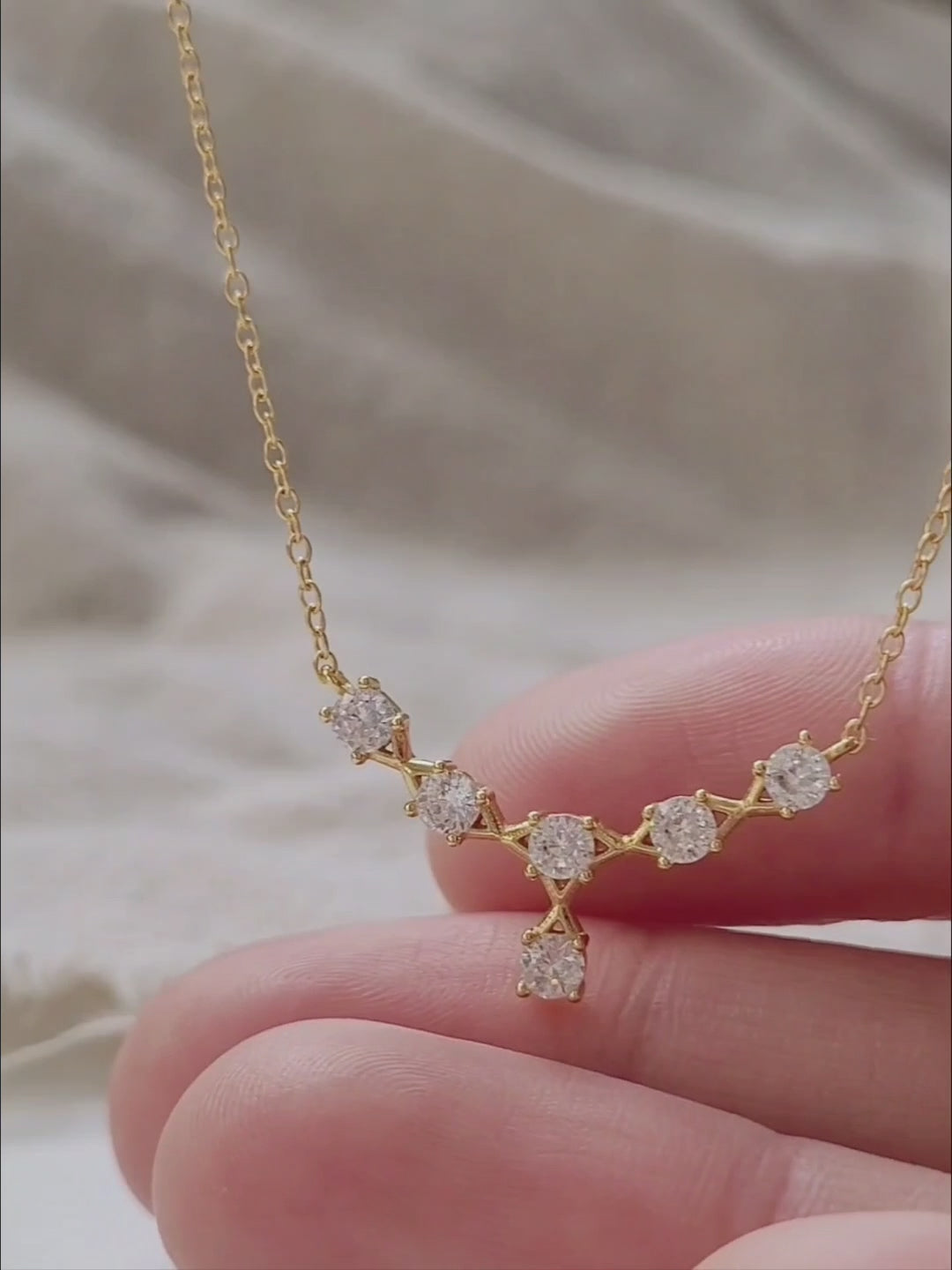 Dainty crystal necklace with crown-inspired design, paired with a sleek gold chain for elegant minimalism.