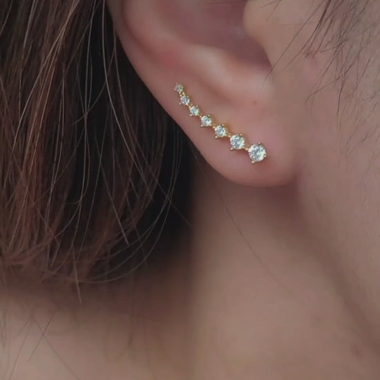 Close-up of a woman's ear wearing an 18K gold-plated cubic zirconia climber earring, highlighting the elegant and minimalist design.