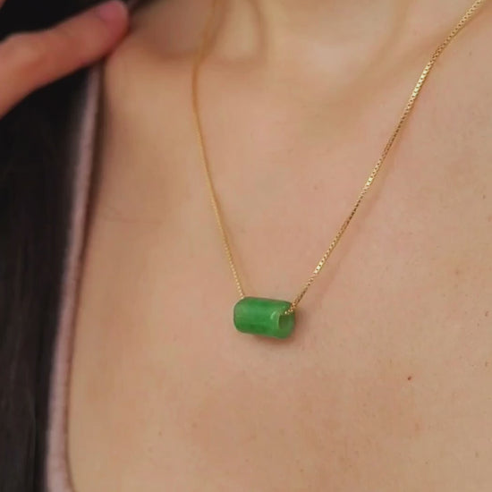 A natural green jade bead necklace with a polished finish, strung on a gold-plated sterling silver chain, offering a minimalist and elegant style.