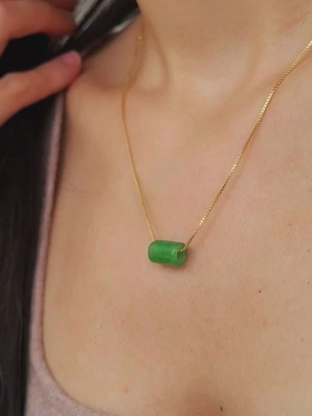 A natural green jade bead necklace with a polished finish, strung on a gold-plated sterling silver chain, offering a minimalist and elegant style.