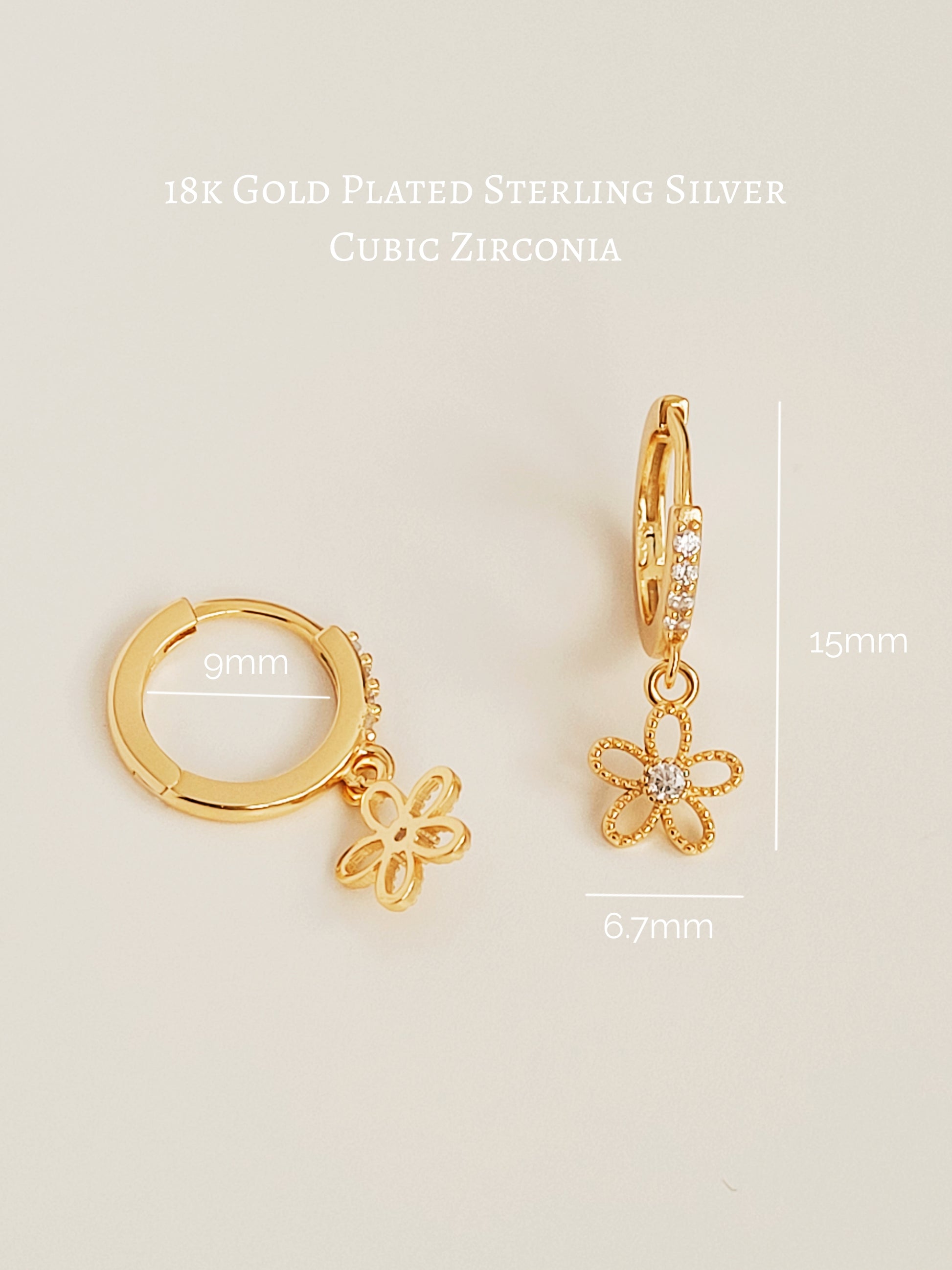 A close-up of a gold huggie earring with a delicate dangling flower charm, crafted in gold plated sterling silver. The intricate flower design adds a touch of femininity, making them ideal as wedding jewelry, a bridesmaid gift, or a thoughtful present for her.