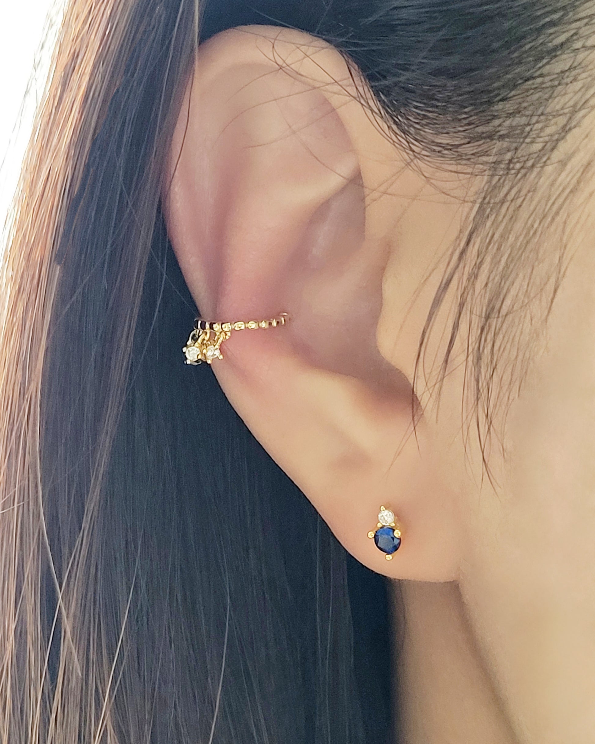 A chic gold-plated ear cuff with three delicate diamonds, blending luxury and style effortlessly.